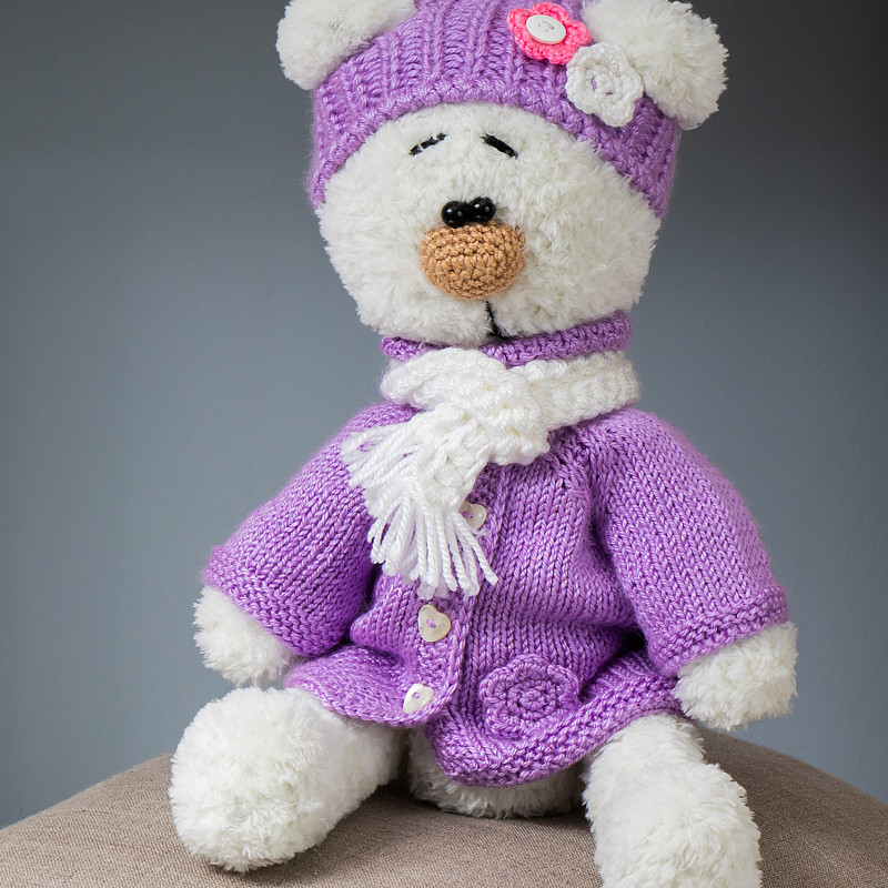 Белый медведь в сиреневом пальто и шапочке
