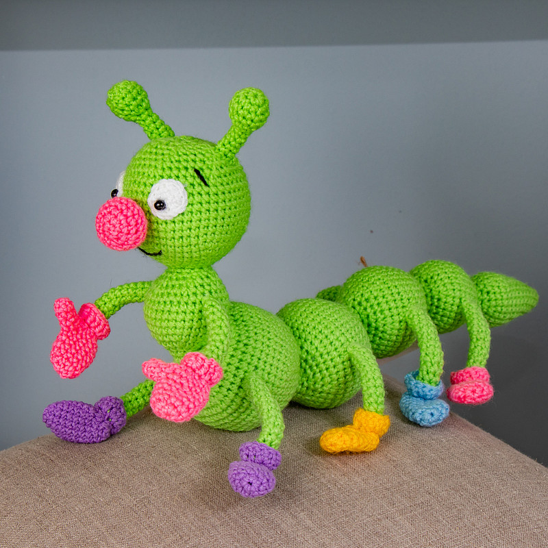 Зеленая гусеница в варежках